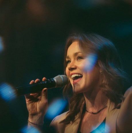 A worship leader singing into a microphone during a church service